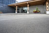 an office building with stone pavers and flower pots in front of it and concrete steps in front