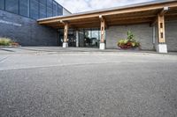 an office building with stone pavers and flower pots in front of it and concrete steps in front