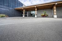 an office building with stone pavers and flower pots in front of it and concrete steps in front