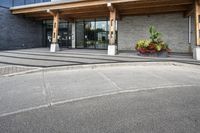 an office building with stone pavers and flower pots in front of it and concrete steps in front