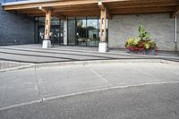 an office building with stone pavers and flower pots in front of it and concrete steps in front