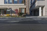 people walk around an empty courtyard surrounded by large buildings on both sides of a street