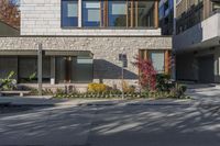 people walk around an empty courtyard surrounded by large buildings on both sides of a street