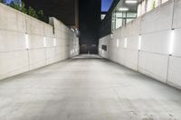 the large concrete wall has been illuminated by recessed lights at night on either side of it