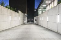 the large concrete wall has been illuminated by recessed lights at night on either side of it