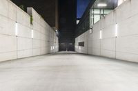 the large concrete wall has been illuminated by recessed lights at night on either side of it