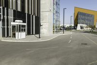 an empty street and a large building in the background with cars on it's way to and from them