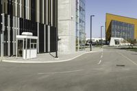 an empty street and a large building in the background with cars on it's way to and from them