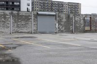 the empty parking lot has only snow on the ground in front of an old brick factory