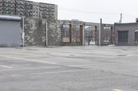 the empty parking lot has only snow on the ground in front of an old brick factory