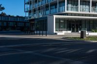 a building on a street corner with some people and cars around it, looking at the building