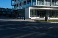 a building on a street corner with some people and cars around it, looking at the building