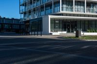 a building on a street corner with some people and cars around it, looking at the building