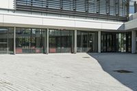 the courtyard in front of a building has several sliding glass doors and a red bench