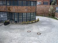 a building has many windows, two doors and brick walls on top of a courtyard