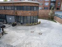 a building has many windows, two doors and brick walls on top of a courtyard