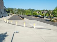 several yellow poles standing in a driveway next to a parking garage on an industrial day