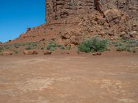 the rocks are brown and brown in color with green shrubs around them and a large, rocky mountain in the background