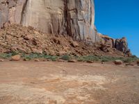 the rocks are brown and brown in color with green shrubs around them and a large, rocky mountain in the background