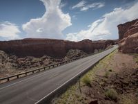 a very narrow mountain road running along a cliff side in arizona, under a cloudy sky