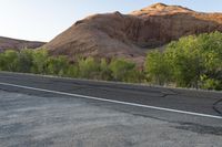 a lone street sign on the side of the road in front of mountains in arizona