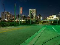 a street in front of the city at night, with neon green lights on either side