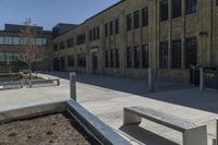 benches sit near a park in front of an old building with a building on either side