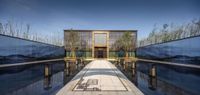 water reflecting in the shadow of two large mirrors outside of the building with a door leading into the pool