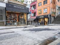 man riding on bike on a city street with buildings and a street sign saying monoclee