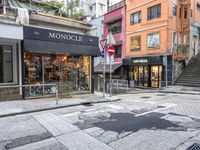 man riding on bike on a city street with buildings and a street sign saying monoclee