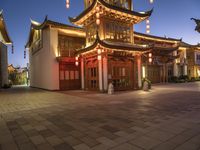 the light is on outside of the asian building at night in the city street, the lanterns are decorated with chinese style lights