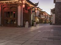 a asian building with lanterns lit up in the front of it's door at dusk