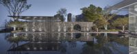 an outdoor reflecting pool with large building in the background and trees next to it,