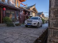 the road is lined with asian style houses and potted plants on each side of a street