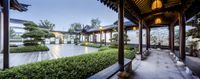 some bushes and trees inside of an asian style house looking towards the pool from a deck