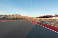 a photo of a dirt race track with sun setting in the distance of the track