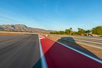 a photo of a dirt race track with sun setting in the distance of the track