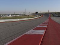 an empty track at a motorsports club with some red and white stripeing on it