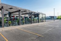 a storefront in an empty parking lot with bicycles outside of it and parked cars behind