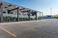 a storefront in an empty parking lot with bicycles outside of it and parked cars behind