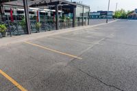 a storefront in an empty parking lot with bicycles outside of it and parked cars behind