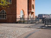 the large building is made of concrete and has metal railings around it, which are made of brick