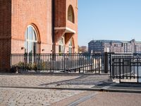 the large building is made of concrete and has metal railings around it, which are made of brick