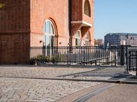 the large building is made of concrete and has metal railings around it, which are made of brick