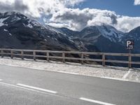 a person skateboarding in front of mountains on a road lined with snow capped mountains