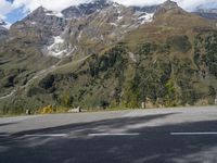 a person on a motorcycle is riding down the street near a mountain backdrop and road markings