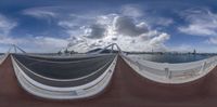 a fisheye view of the city by the water and the bridge on the other side of it