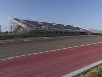 an empty track at a motorsports club with some red and white stripeing on it