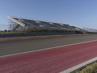 an empty track at a motorsports club with some red and white stripeing on it