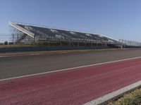 an empty track at a motorsports club with some red and white stripeing on it